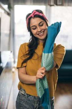 Eldiven takan ve evi temizlemeye hazır mutlu bir kadın.. 