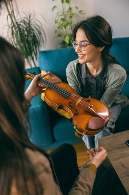 Kemanı tutan ve öğrencisine evde nasıl yapılacağını öğreten müzik öğretmeni.. 
