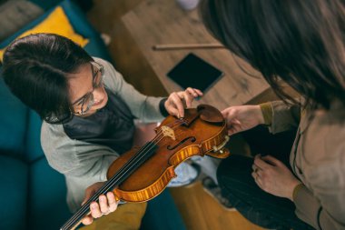 Kemanı tutan ve öğrencisine evde nasıl yapılacağını öğreten müzik öğretmeni.. 