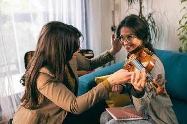 Müzik öğretmeni, özel derste öğrencisine keman tutmayı öğretiyor.. 