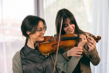 Müzik öğretmeni, öğrencisine evde keman çalmayı öğretiyor.. 