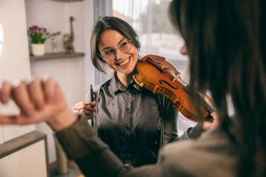 Müzik öğretmeni keman çalmayı öğrenen öğrencisine parmaklarını nasıl tutacağını anlatıyor.. 