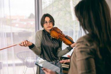Öğrencisinin kafası karışıkken öğrencisine keman çalmayı öğretiyor.. 