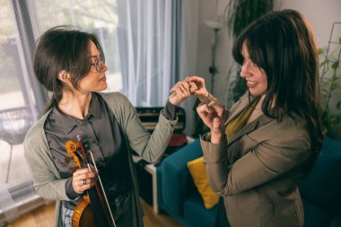 Müzik öğretmeni keman çalmayı öğrenen öğrencisine parmaklarını nasıl tutacağını anlatıyor.. 