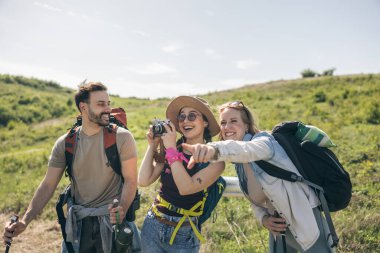Üç mutlu arkadaş doğa yürüyüşü yaparken ve kamerayla fotoğraf çekerken eğleniyorlar.. 