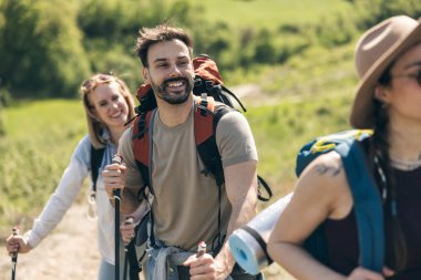 Genç gülümseyen ve mutlu arkadaşlar tatil sırasında ormanı keşfediyorlar.. 
