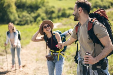 Genç gülümseyen ve mutlu arkadaşlar tatil sırasında ormanı keşfediyorlar.. 