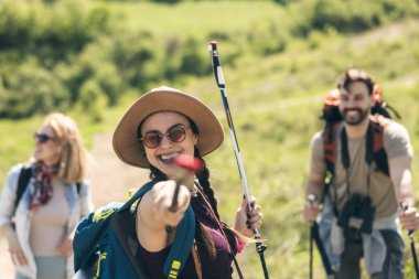 Üç mutlu arkadaş yürüyüş gününün tadını çıkarırken sırıkla eğleniyorlar.. 
