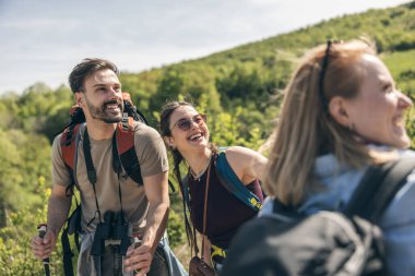 Bir grup arkadaş güneşli bir günde kır yürüyüşünde eğleniyorlar. 