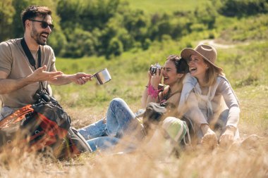 Güneşli bir günde kırsalda yürüyüş yapan arkadaşlar piknik yapıyor.. 