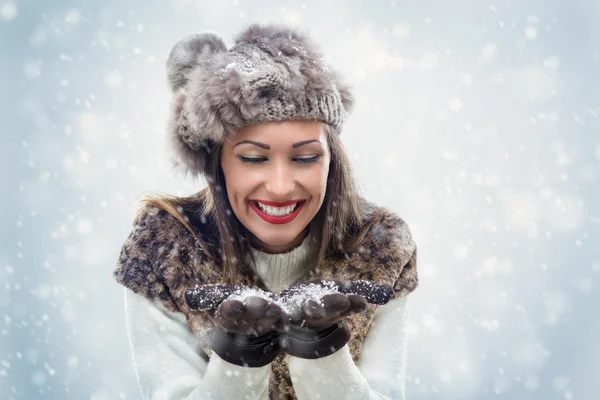 Niedliches Mädchen bläst Schneeflocken — Stockfoto