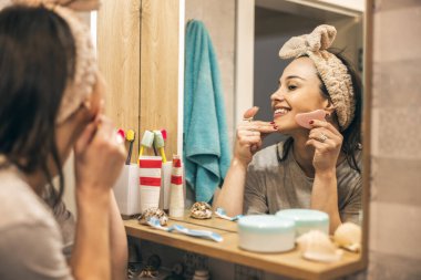Tuvalette cilt bakımı yaparken cilt bakımı yapan bir kadın..