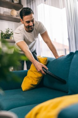 Adam evdeki bahar temizliğinde temizlik ve süpürge yapıyor..