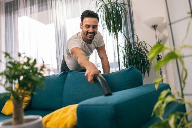 Adam evdeki bahar temizliğinde temizlik ve süpürge yapıyor..