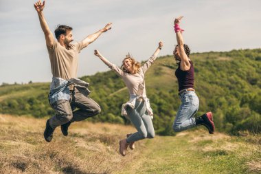 Güneşli bir günde kırsalda mutlu ve neşeli bir şekilde zıplamak..
