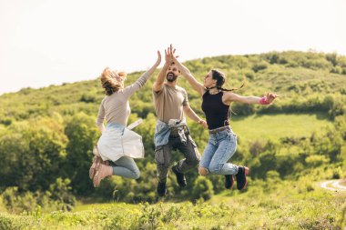 Güneşli bir günde kırsalda mutlu ve neşeli bir şekilde zıplamak..
