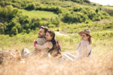 Mutlu ve neşeli arkadaşlar güzel güneşli bir günde pikniklerde eğleniyorlar..