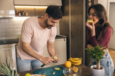 Mutlu, neşeli bir çift meyve hazırlıyor ve muzları birleştiriyor..