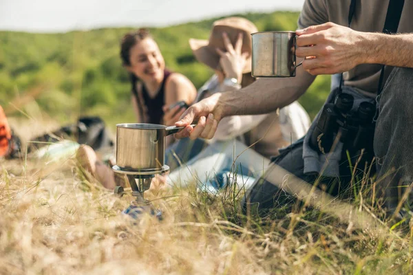 Güneşli bir günde kırsalda yürüyüş yapan arkadaşlar piknik yapıyor..