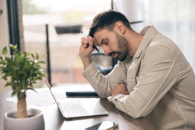 İşadamı evindeki bilgisayarla uğraşırken endişeli görünüyor..