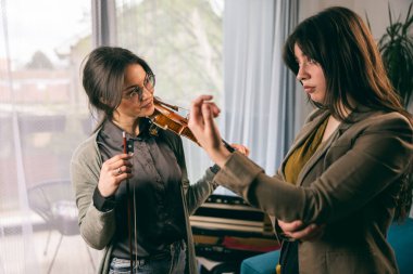 Müzik öğretmeni keman çalmayı öğrenen öğrencisine parmaklarını nasıl tutacağını anlatıyor..