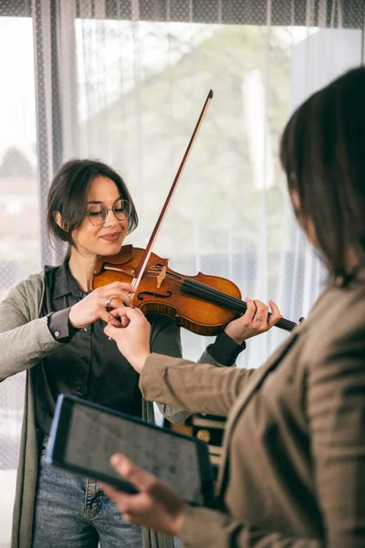 Müzik öğretmeni keman çalmayı öğrenen öğrencisine parmaklarını nasıl tutacağını anlatıyor..