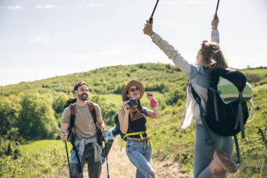 Neşeli arkadaşlar doğada güneşli yürüyüş gününün tadını çıkarırken eğleniyorlar..