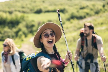 Üç mutlu arkadaş yürüyüş gününün tadını çıkarırken sırıkla eğleniyorlar..