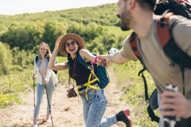 Genç gülümseyen ve mutlu arkadaşlar tatil sırasında ormanı keşfediyorlar..
