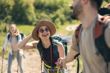 Genç gülümseyen ve mutlu arkadaşlar tatil sırasında ormanı keşfediyorlar..