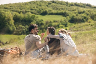 Mutlu ve neşeli arkadaşlar güzel güneşli bir günde pikniklerde eğleniyorlar..