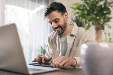 İş adamı evindeki bilgisayarında ve tabletinde çalışıyor..