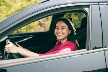 Arabayı kullanan genç bir kadın portresi.