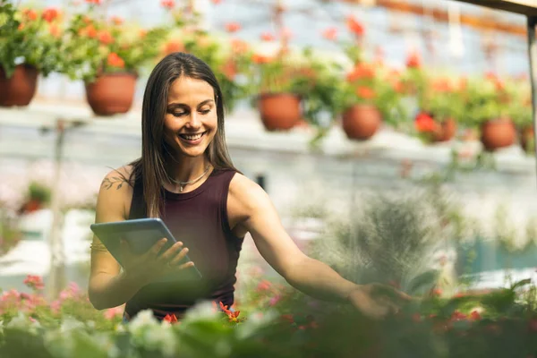 Serada duran ve tablet kullanan neşeli genç bir kadın..