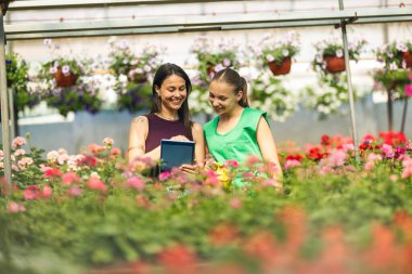 İki çiçekçi çiçeklerle ilgili konuşup duruyor..