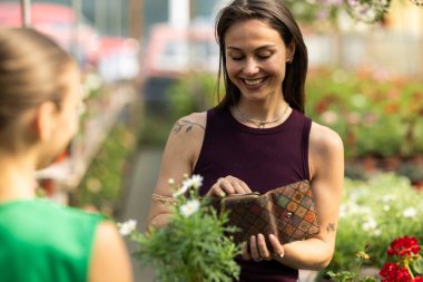 Gülümseyen kadın seradan çiçek alıyor..