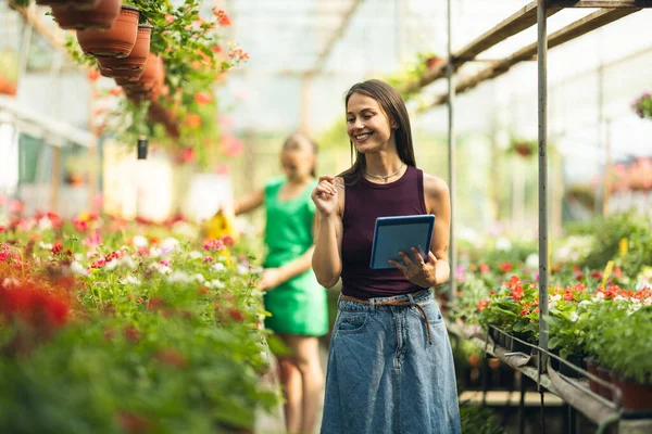 Serada duran ve tablet kullanan neşeli genç bir kadın..