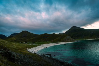 Norveç 'in Lofoten kentindeki Unstad köyüne giden yürüyen trende sahilde ve dağlarda manzaralı bir manzara.