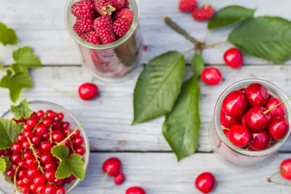 Freshly picked cherries raspberry fruits table — Stock Photo, Image