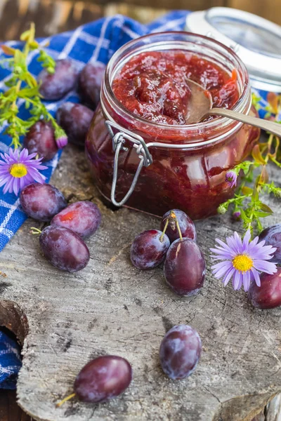 Frascos geléia de ameixa mesa de madeira — Fotografia de Stock