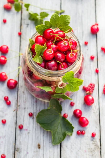 Pot en verre plein de fruits cerises et groseilles — Photo