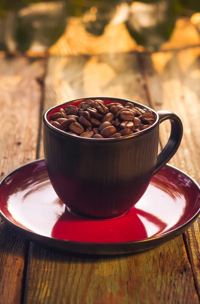 Kopje zwarte koffie vol bonen — Stockfoto