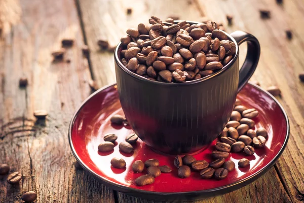 Kopje zwarte koffie vol bonen — Stockfoto