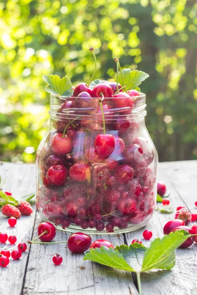 Frasco de vidrio frutas cerezas frambuesas — Foto de Stock