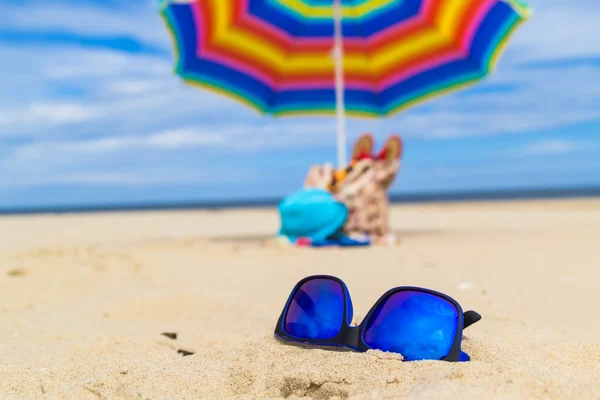Occhiali da sole blu sfondo ombrello — Foto Stock