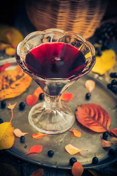 Na podzim kuchyně pohár tinktura černoplodá sušená dřevěný stůl — Stock fotografie