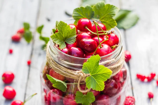 Tarro de vidrio lleno de frutas cerezas y grosellas —  Fotos de Stock