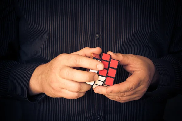 Man probeert oplossen Rubik kubus — Stockfoto