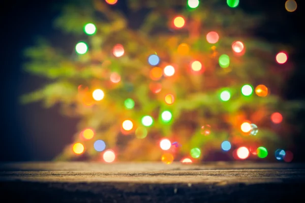 Feestelijke achtergrond houten tafel kerstboom lichten — Stockfoto