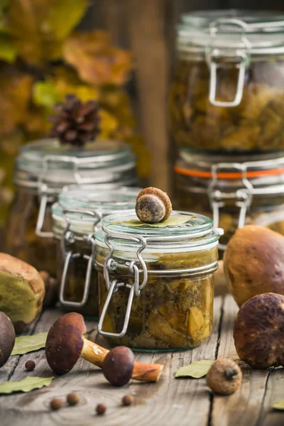 Cogumelos marinados jarros mesa de madeira — Fotografia de Stock